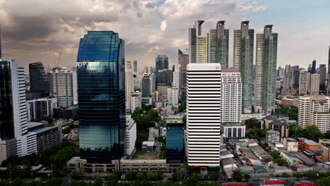 skyscrapers at banchakitti park in downtown bangkok under cloudy sky, aerial