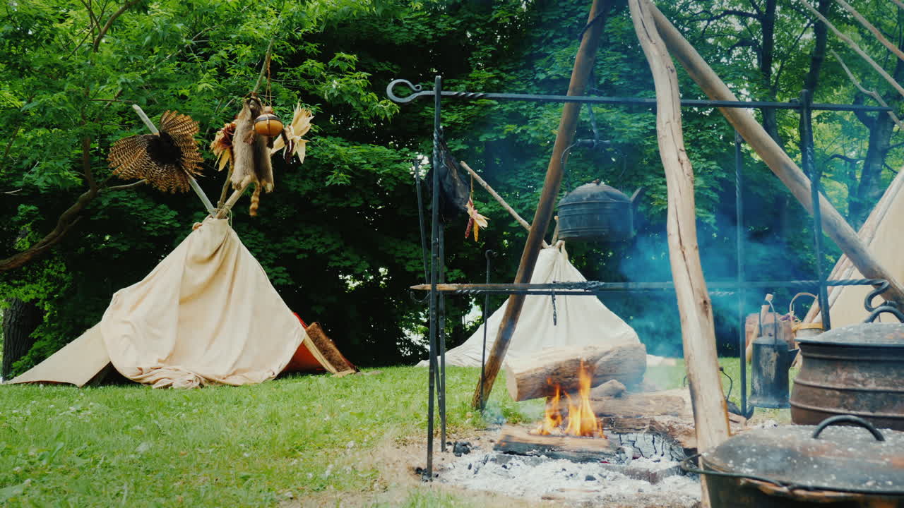 숲 음식에 있는 아메리카 원주민 캠프가 전경 전통 wigwam 텐트에서 준비되고 있습니다.