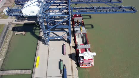 quay cranes loading london thamesport,container port river medway kent uk drone aerial view