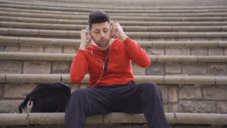 Joven-Escuchando-Música-Al-Aire-Libre-Usando-Auriculares.