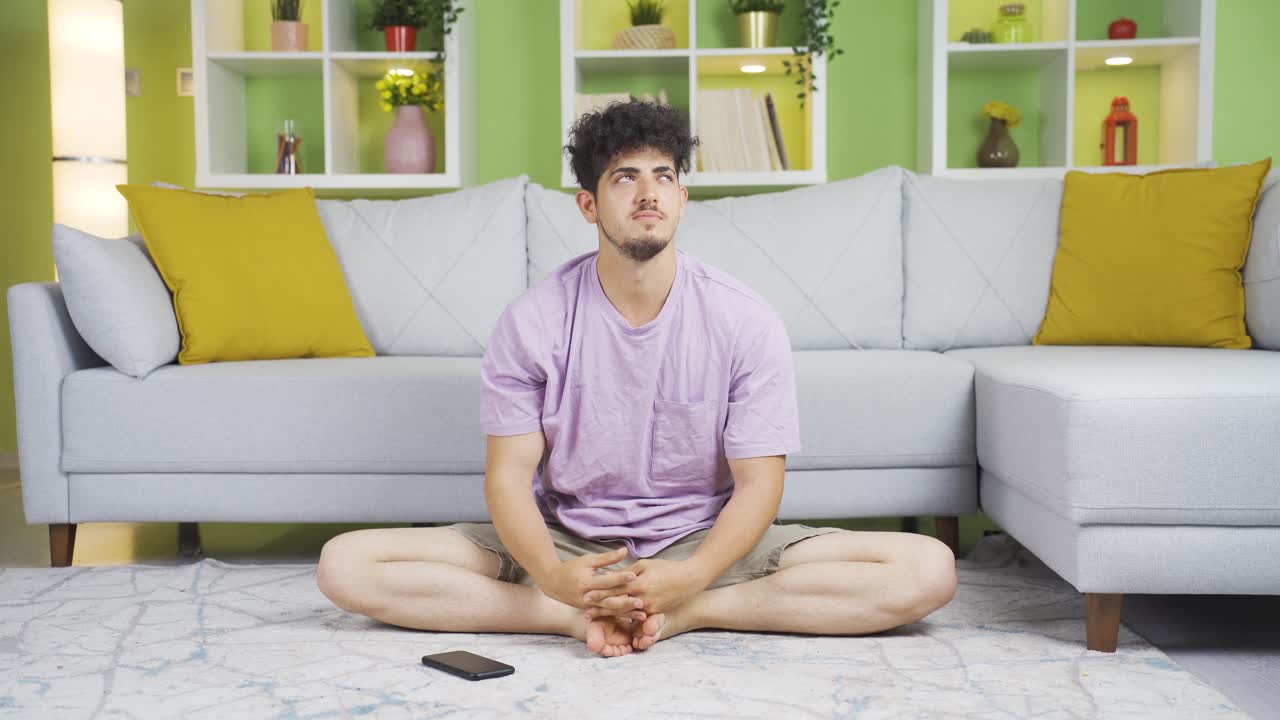 In the casual home, the young man is thoughtful.