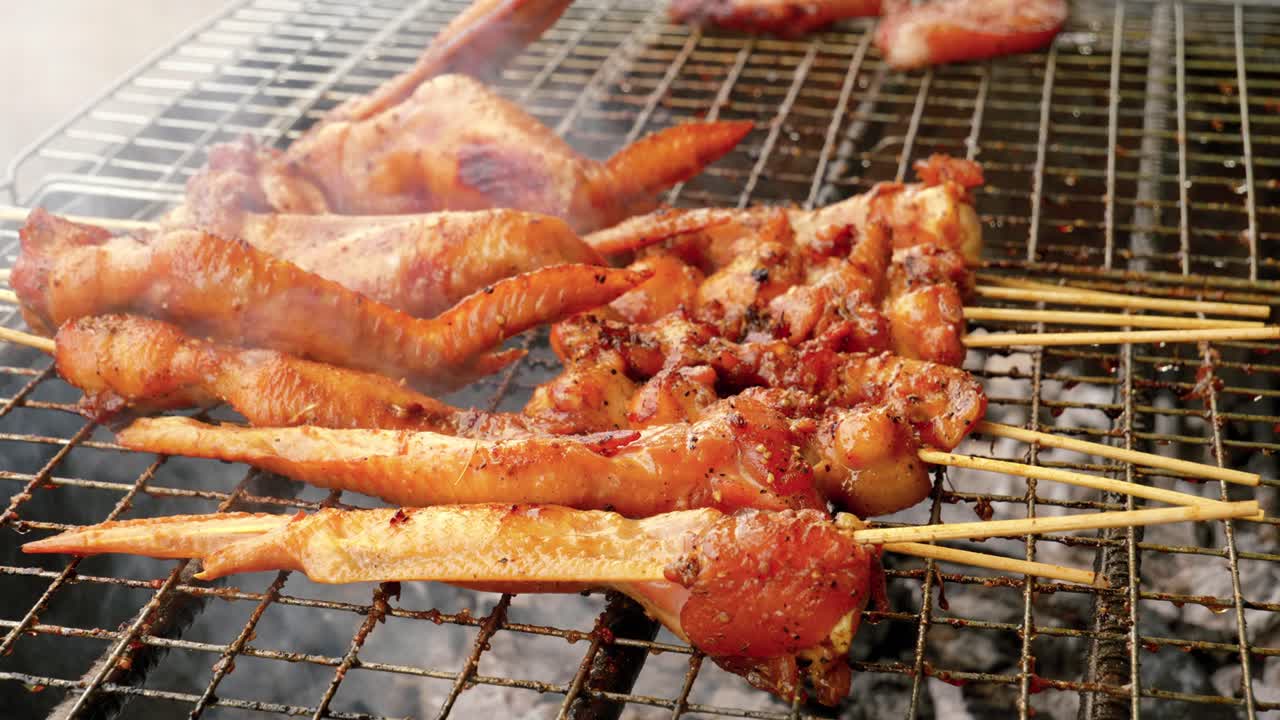 유명한 길거리 음식의 클로즈업 샷은 숯불 난로, 태국, 난 지방에서 굽고 있는 닭 날개를 망쳤습니다.