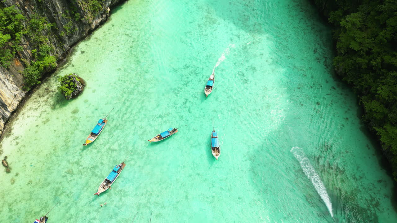 aguas turquesas cristalinas y acantilados de piedra caliza en la bahía de maya en las islas phi phi, barcos de cola larga en la bahía de maya, tailandia, vista aérea