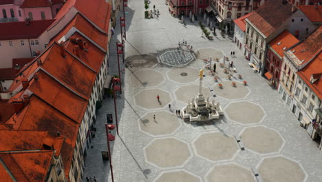 Vista-Aérea-De-Pocas-Personas-En-La-Plaza-Principal-Con-El-Monumento-De-La-Columna-De-La-Peste-En-Eslovenia