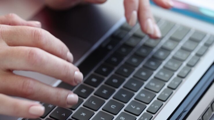 Hands typing on a laptop keyboard