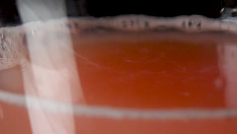 macro shot of a drop from a grapefruit juice in slow motion