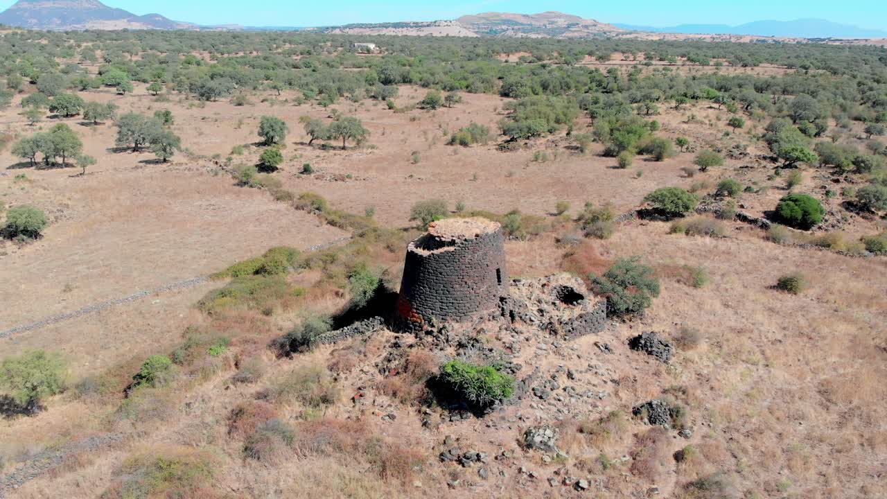 Drönare cirkulerar Nuraghe i centrala Sardinien, Italien, över ett torrt sommarlandskap