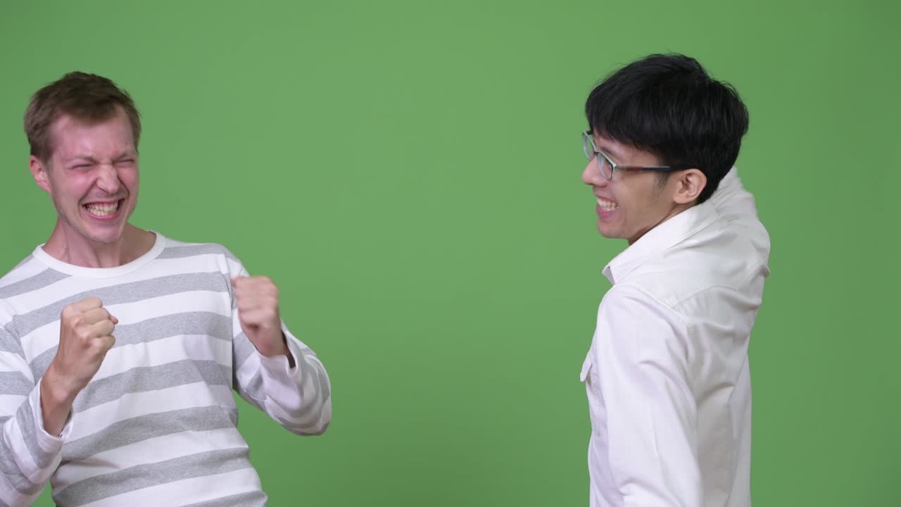 두 명의 행복한 젊은 다민족 사업가들이 함께 흥분하고 축하하고 있습니다.