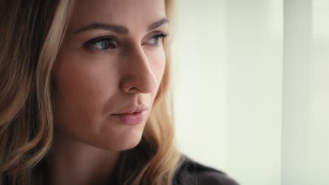 extreme tilt up of depressed young caucasian woman next to the window.