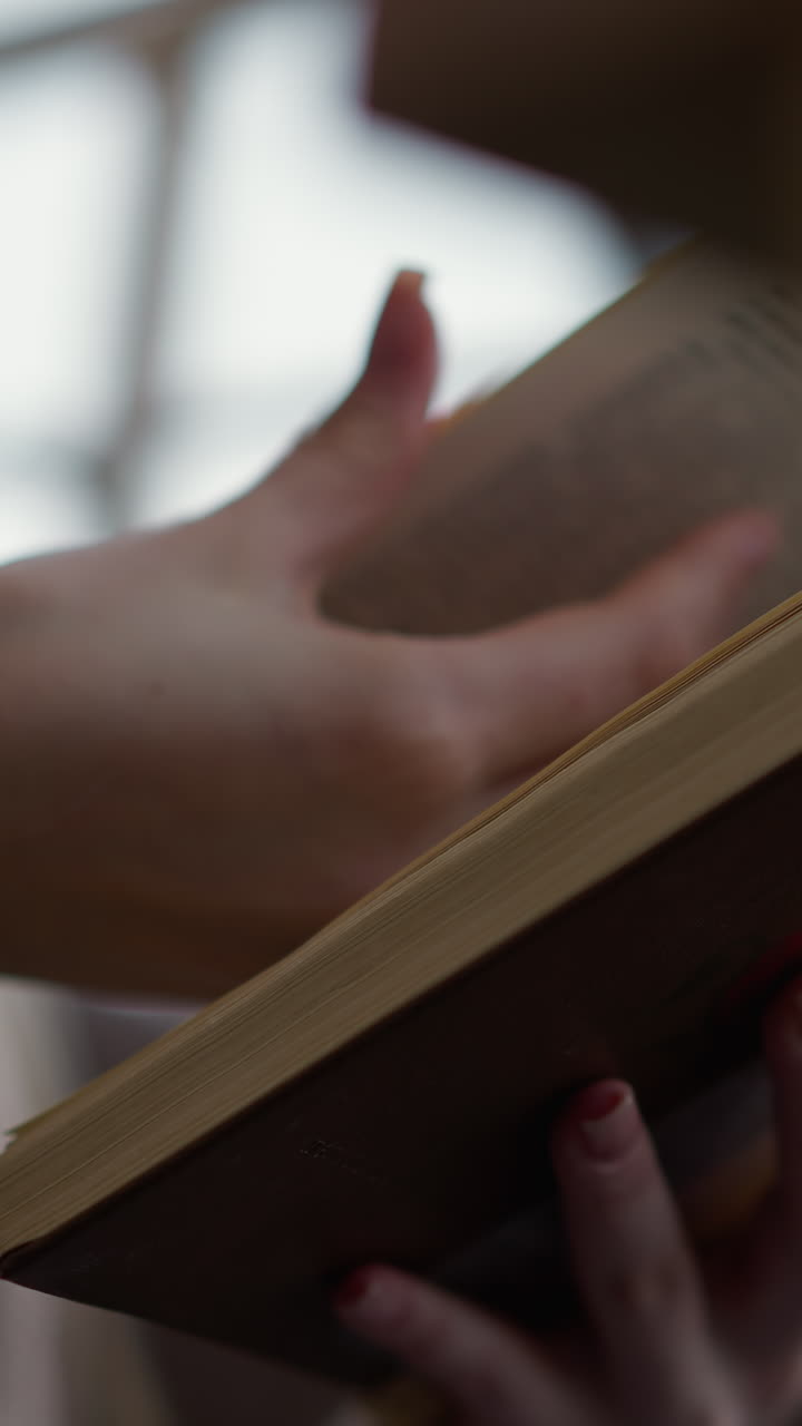 primer plano de una mano girando suavemente hacia una nueva página en un libro con enfoque en los dedos y la textura del libro, fondo suave que destaca la experiencia de lectura pacífica