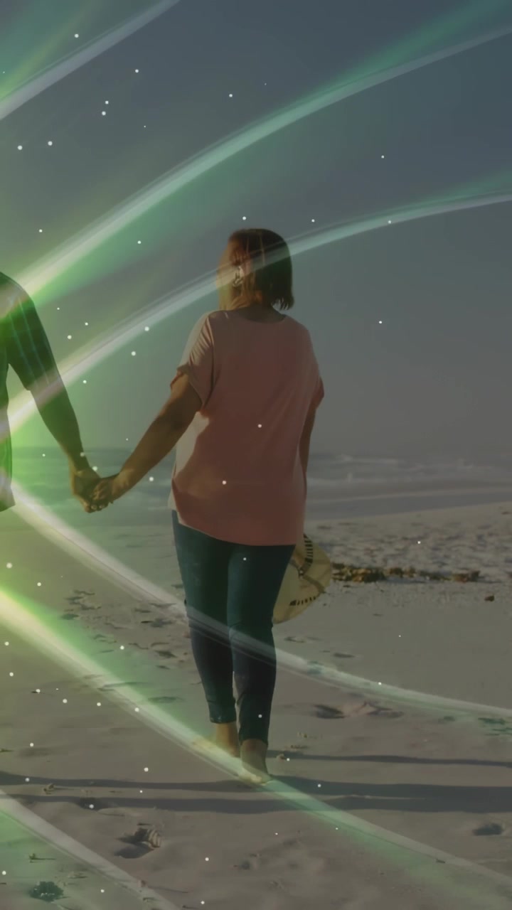 Video verticale: Coppia che cammina verso il mare tenendosi per mano, cappello che lascia impronte, nastro verde che accompagna il viaggio.