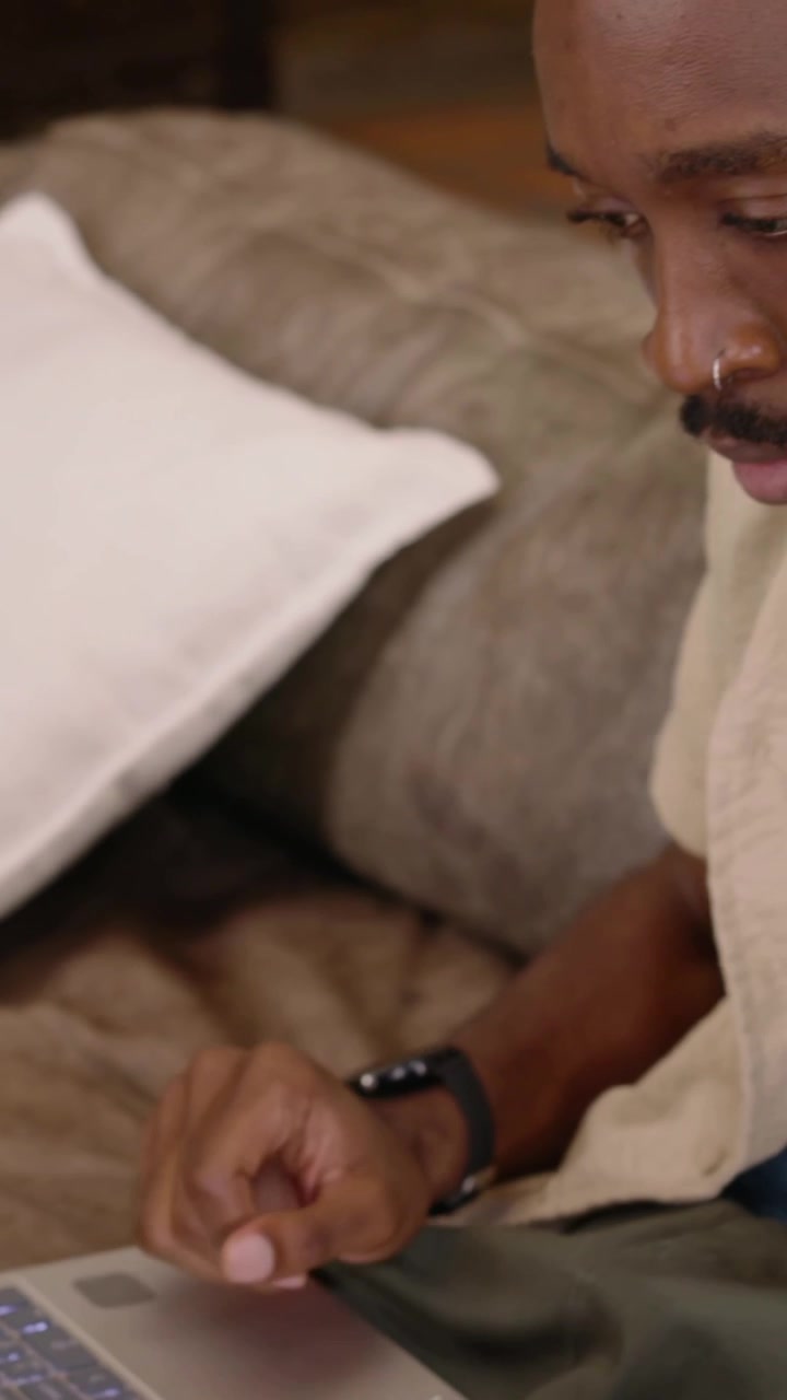 Vertikal video: Ser chat-advarsel, mand med smartwatch svarer mens han læser History Chat derhjemme.
