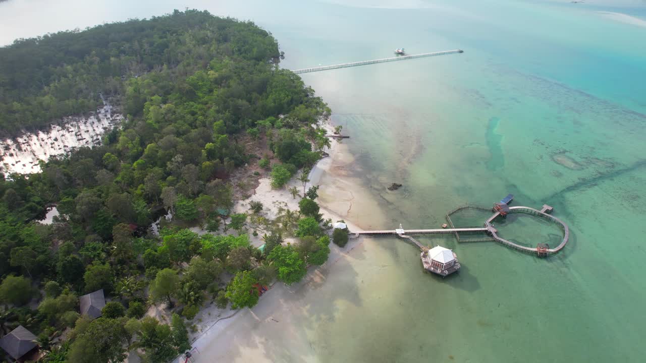 Aerial Descending Towards Leebong Island's Over Water Bungalows Resort with Long Wooden Piers Over Emerald Sea in Belitung Indonesia