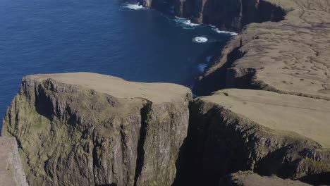 Aerial-view-of-tourist-crossing-Rituskor-gorge-bridge-on-Suduroy-island,-Faroe-Islands