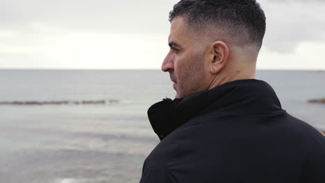 a man pensively looking out to sea in slow motion with copy space