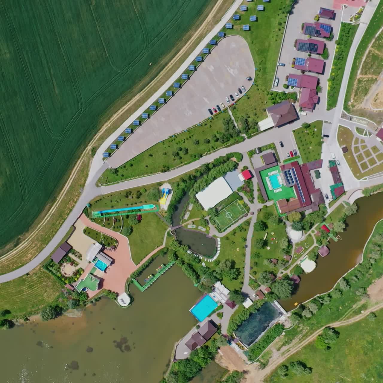 Modern resting zone. Panoramic view of a recreation complex surrounded by beautiful nature in summer. Aerial view. Camera moving around.