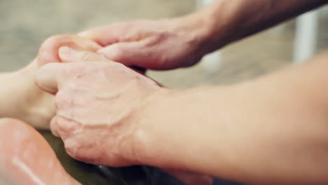 foot massage in spa salon. professional therapist giving relaxing reflexology foot massage to a woman in spa