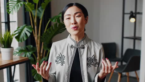 confident asian businesswoman gesturing and smiling