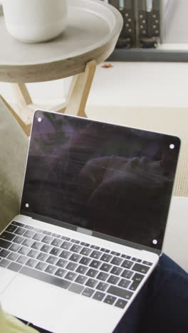 video of plus size african american woman sitting on sofa with laptop with copy space