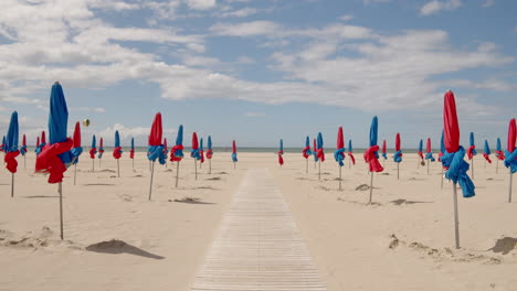 Paseo-Marítimo-Con-Coloridas-Sombrillas-En-La-Playa-De-Deauville-En-Normandía,-Norte-De-Francia