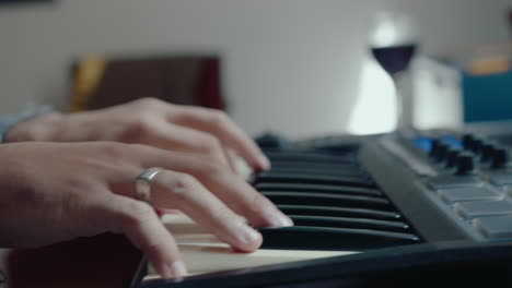 hands of musician playing synthesizer and recording track