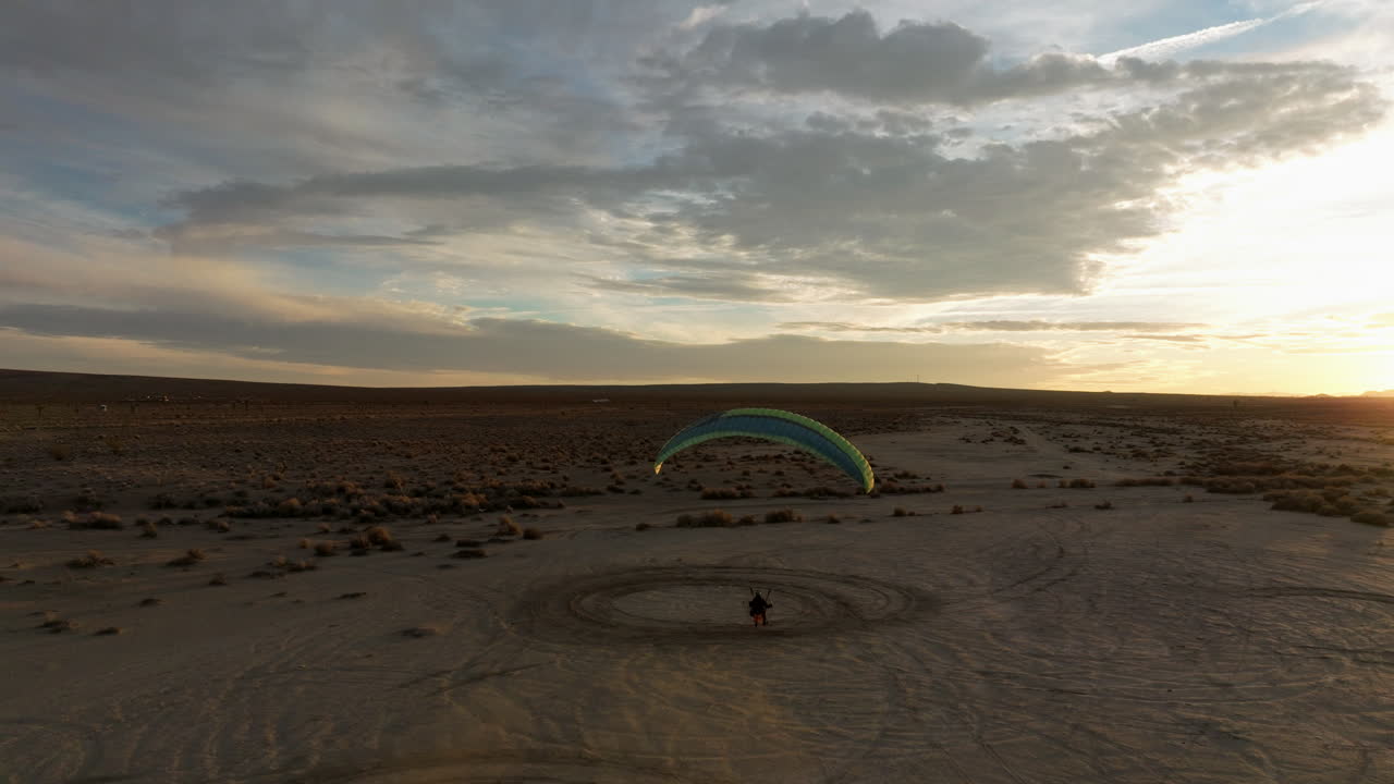 parapente motorizado a baja altura justo por encima del paisaje arenoso del desierto de mojave y luego se eleva hasta el colorido cielo del atardecer