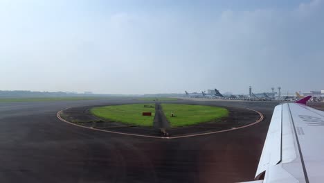 airplane on runway at busy airport, clear sky, sense of travel