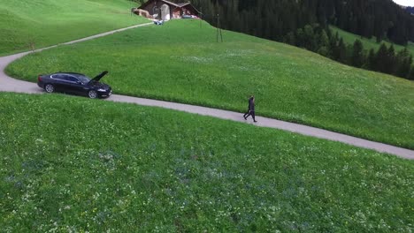 rural swiss road with broken down car and walking person