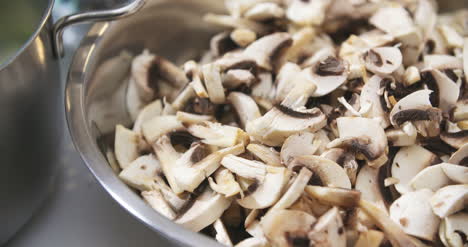 chef slicing mushrooms in kitchen