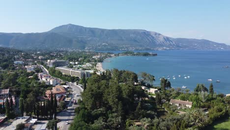 ascending drone flight over corfu island reveals dassia bay and lush scenery in greece