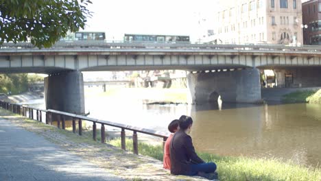 一对夫妇坐在河边聊天在京都,日本柔软的照明慢动画4k