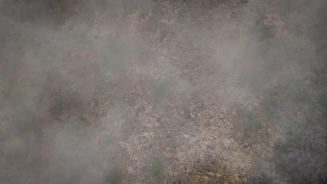 Top-down drone shot descending at Paso de Cortés in the metropolitan area of Mexico City after passing through a cloud bank