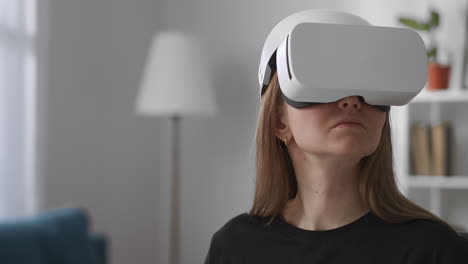 Frau-Betrachtet-Virtuelle-Realität-Durch-Modernes-Head-Mounted-Display-Im-Wohnzimmer,-Mittleres-Porträt-Einer-Weiblichen-Benutzerin-Im-Innenbereich,-Gerät-Für-Videospiele-Und-Bildung