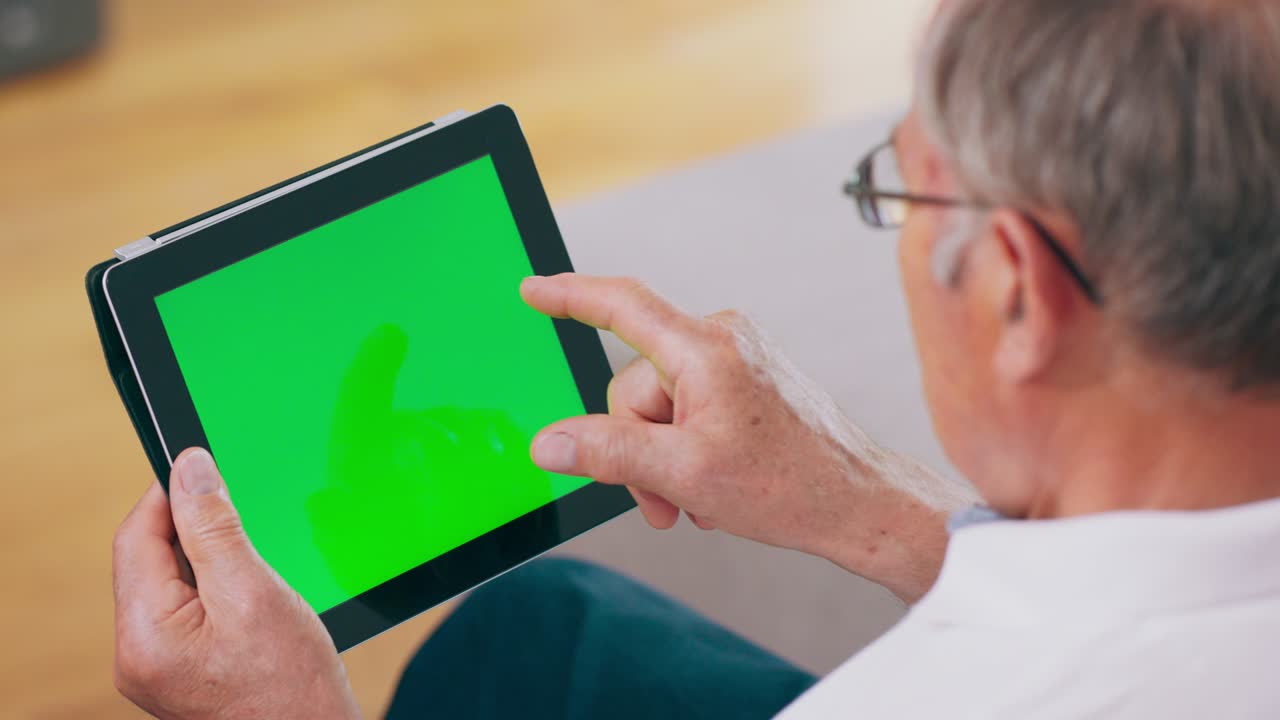 할아버지는 녹색 화면의 태블릿 컴퓨터를 사용합니다.