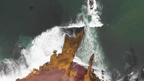 spinning aerial shot as waves washing the shore at the red beach paracas national park peru