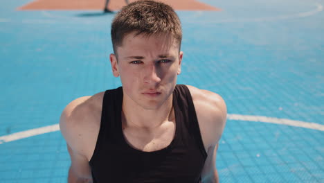 portrait of tired athletic caucasian man in sportswear relaxing after playing basketball game