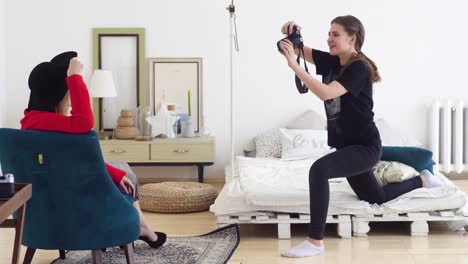 woman taking photos of a model in a bedroom