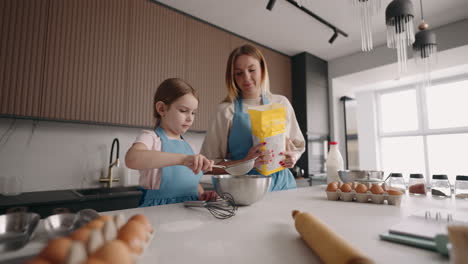 Feliz-Ocio-Familiar-En-Fin-De-Semana-La-Madre-Está-Enseñando-A-Su-Pequeña-Hija-A-Cocinar-Pizza-Tamizando-Harina-Juntas