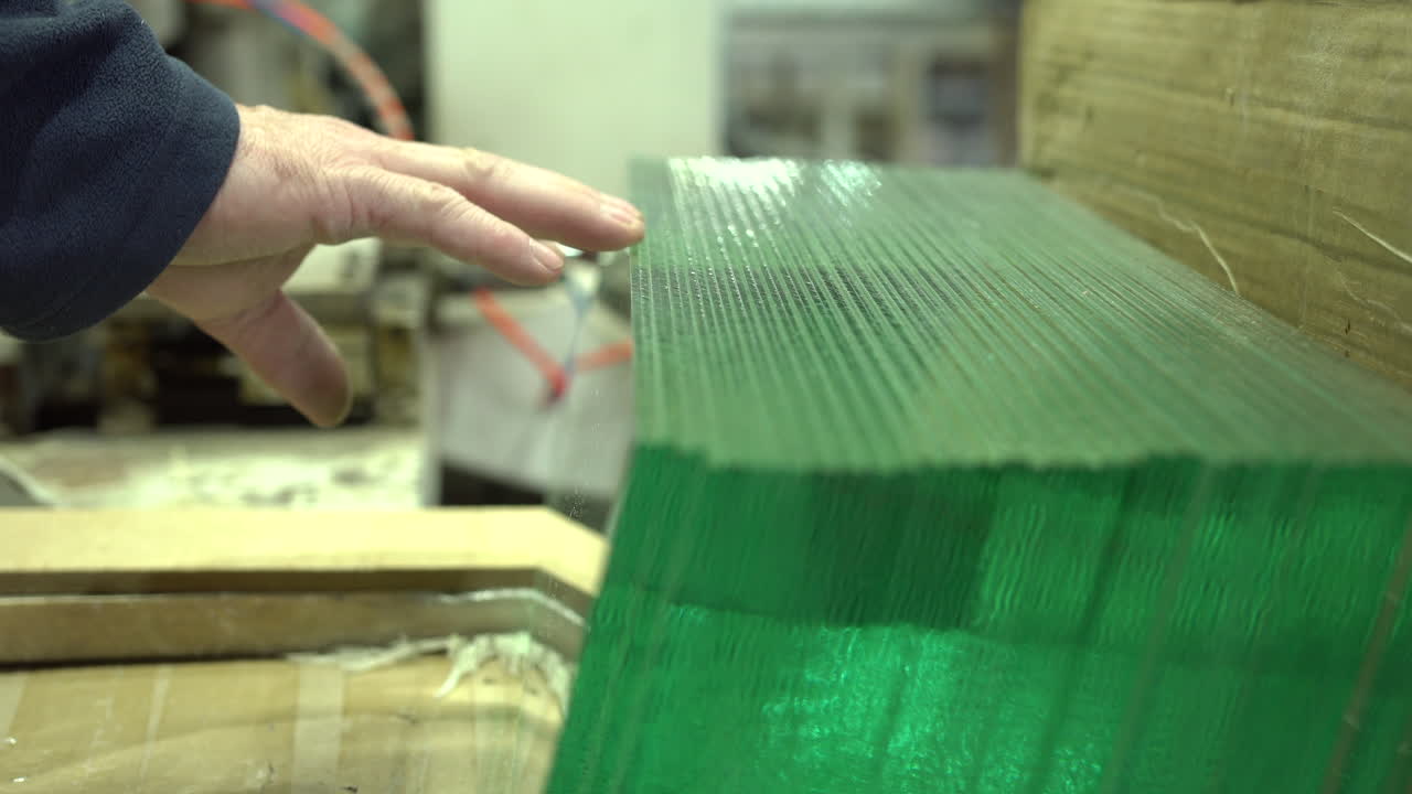 recogiendo el panel de vidrio de la fila perfectamente almacenada en el taller