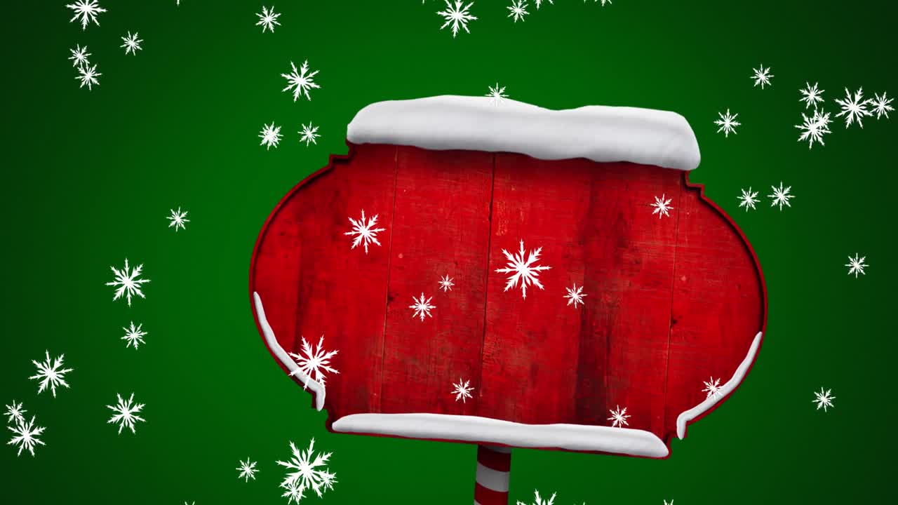 녹색 배경을 배경으로 빨간 나무 표지판 위에 떨어지는 눈송이의 디지털 애니메이션