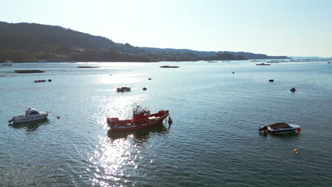 An-old-fishing-boat-in-a-river-surrounded-by-smaller-vessels