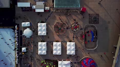 Flying-Over-a-Winter-Fair-with-People-Skating-at-Toronto-City-Hall,-Wide-Aerial-Dolly