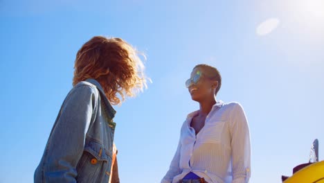 Female-friends-interacting-with-each-in-the-beach-4k