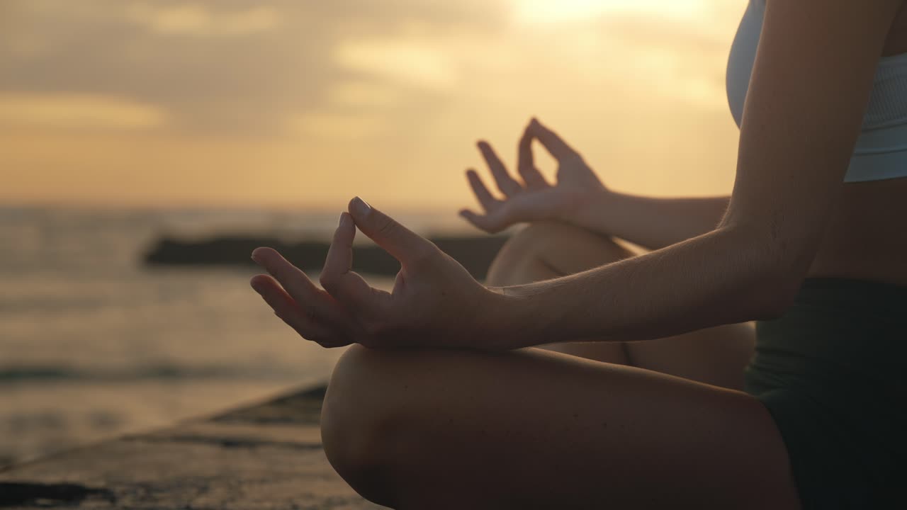 dedos pulgar e índice tocándose en la pose de meditación zen de manos femeninas, atardecer