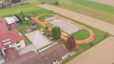 una vista de drones sobre hermosas canchas de baloncesto en un pueblo adornado con hermosas casas y vegetación