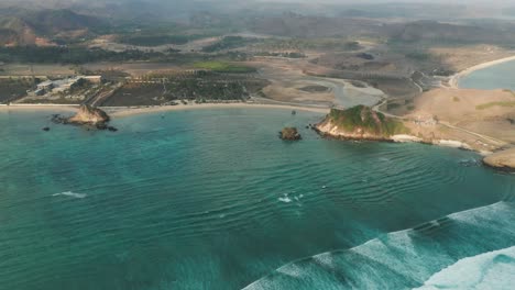 tropical ocean waves reaching dry shore of island lombok in indonesia, aerial