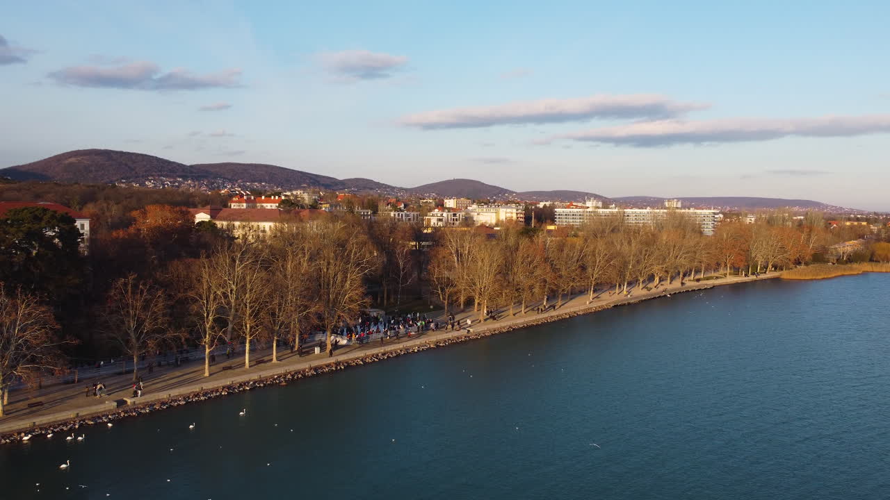 Golden hour over Balatonfured pier with hills and shoreline under soft light of sunset