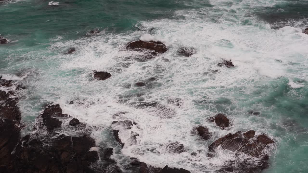 Filmato tranquillo e rilassante di bellissime onde blu dell'oceano che si infrangono sulla costa rocciosa alla Gola di Loch Ard, Costa dei Dodici Apostoli ed entroterra di Port Campbell