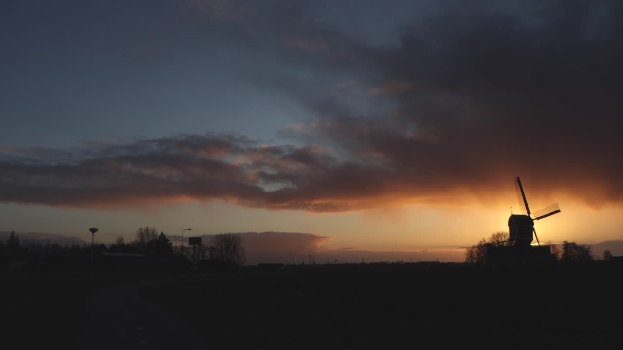 네덜란드 에서 해가 지는 동안 오래된 풍차 를 지나가는 교통