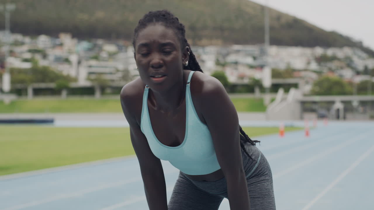 Tired Woman Athlete Taking a Break on a Track
